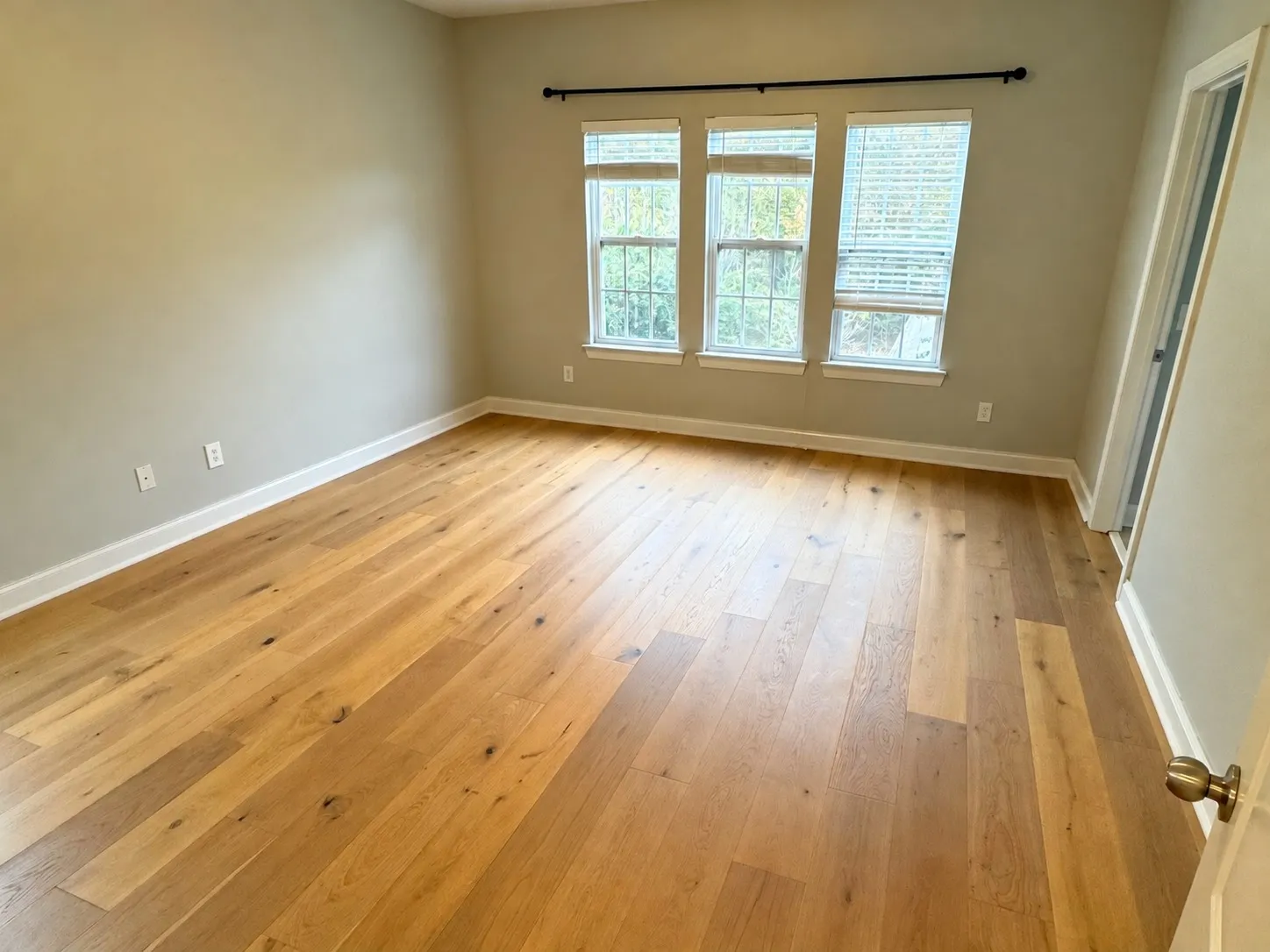 After hardwood installation: Bedroom, worn carpet to wide-plank hardwood
