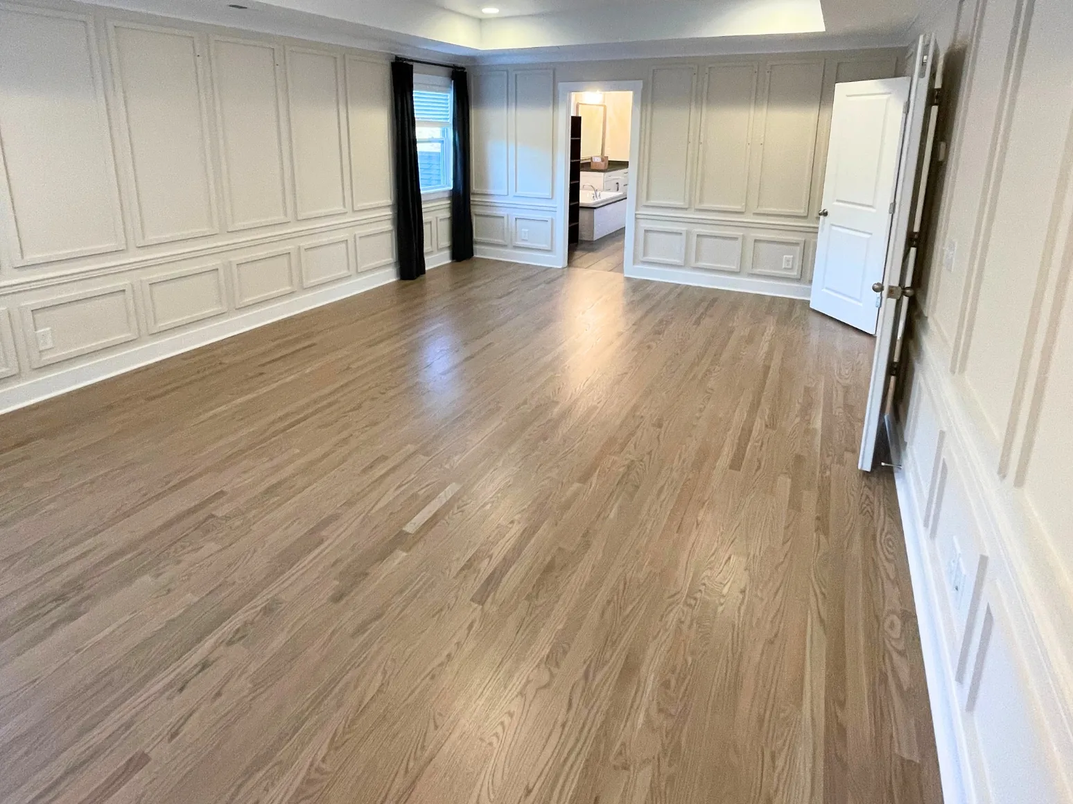 After hardwood installation: Primary suite, carpet to gray-washed oak