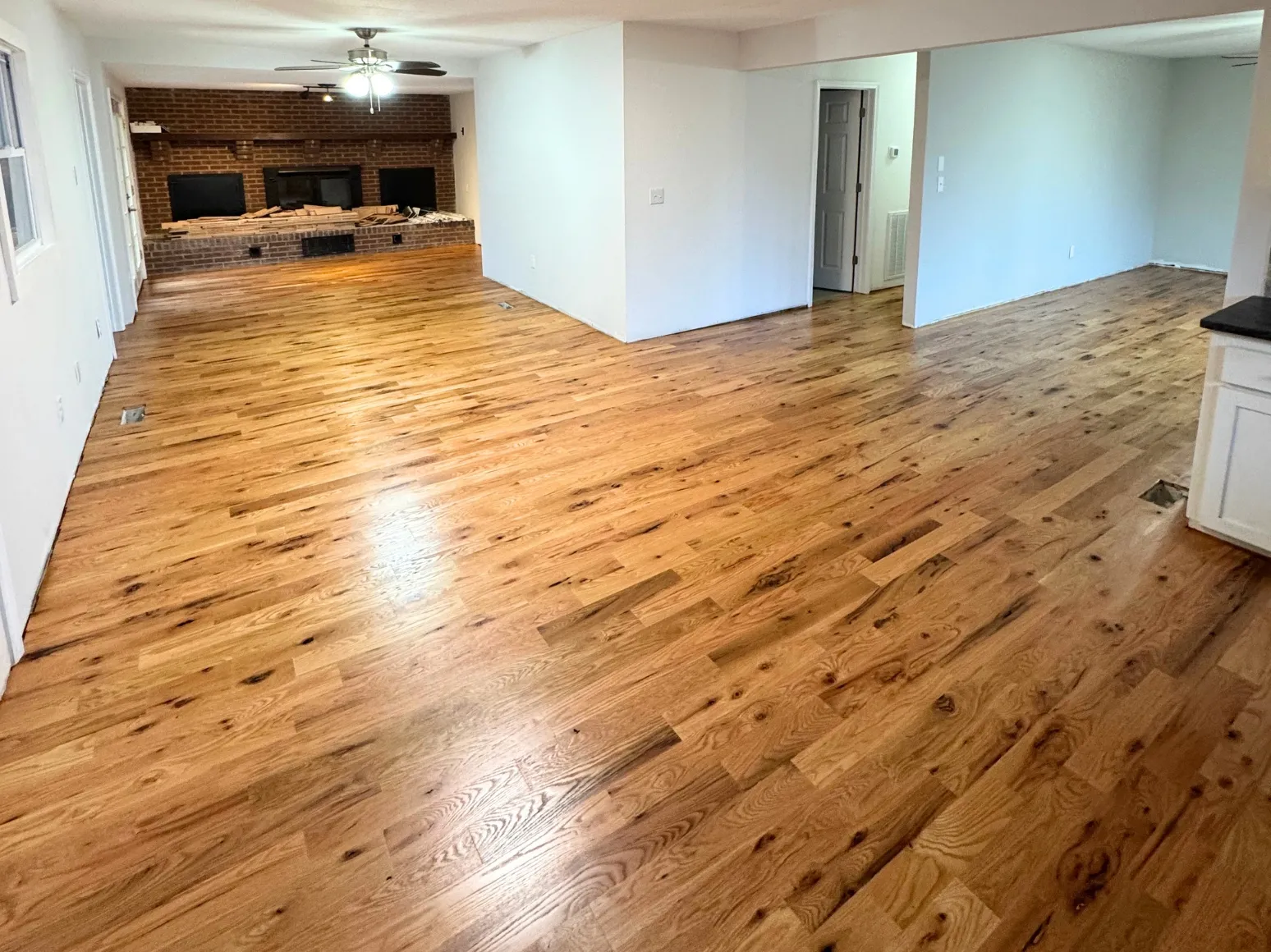 After hardwood installation: Open lower level, bare subfloor to oak