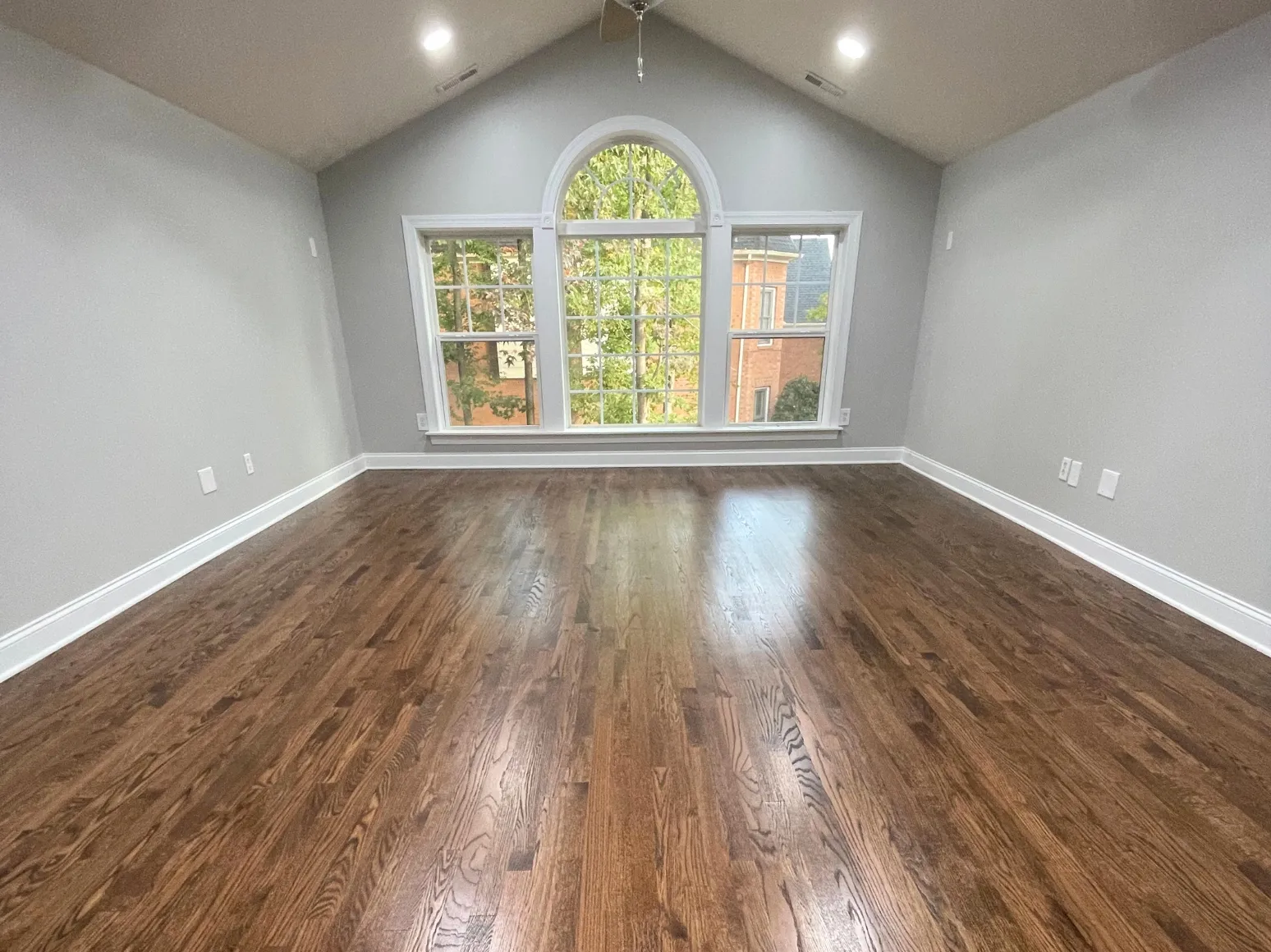 After hardwood installation: Vaulted bonus room, carpet to dark hardwood