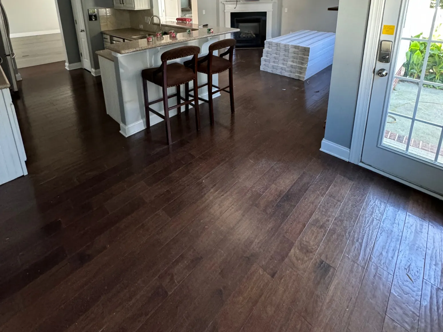 Before hardwood installation: Kitchen and living area, dark floor to light wide plank