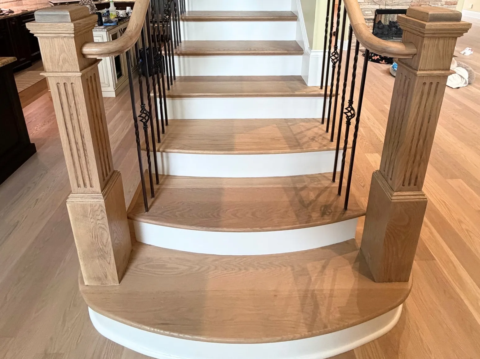 After staircase refinishing: Curved entry stairs, dark stain to natural oak