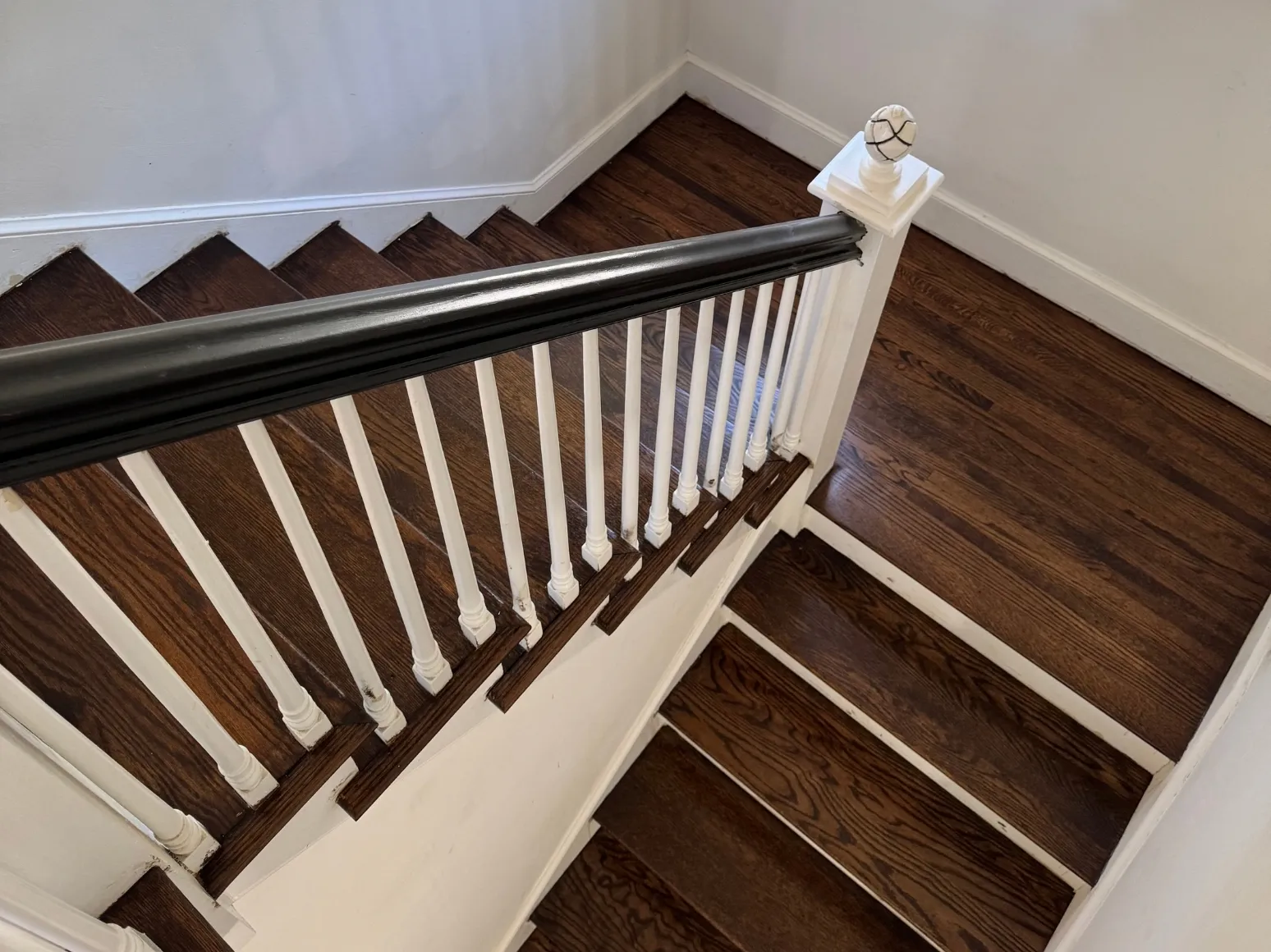 After staircase refinishing: Staircase with black rail, deep brown treads