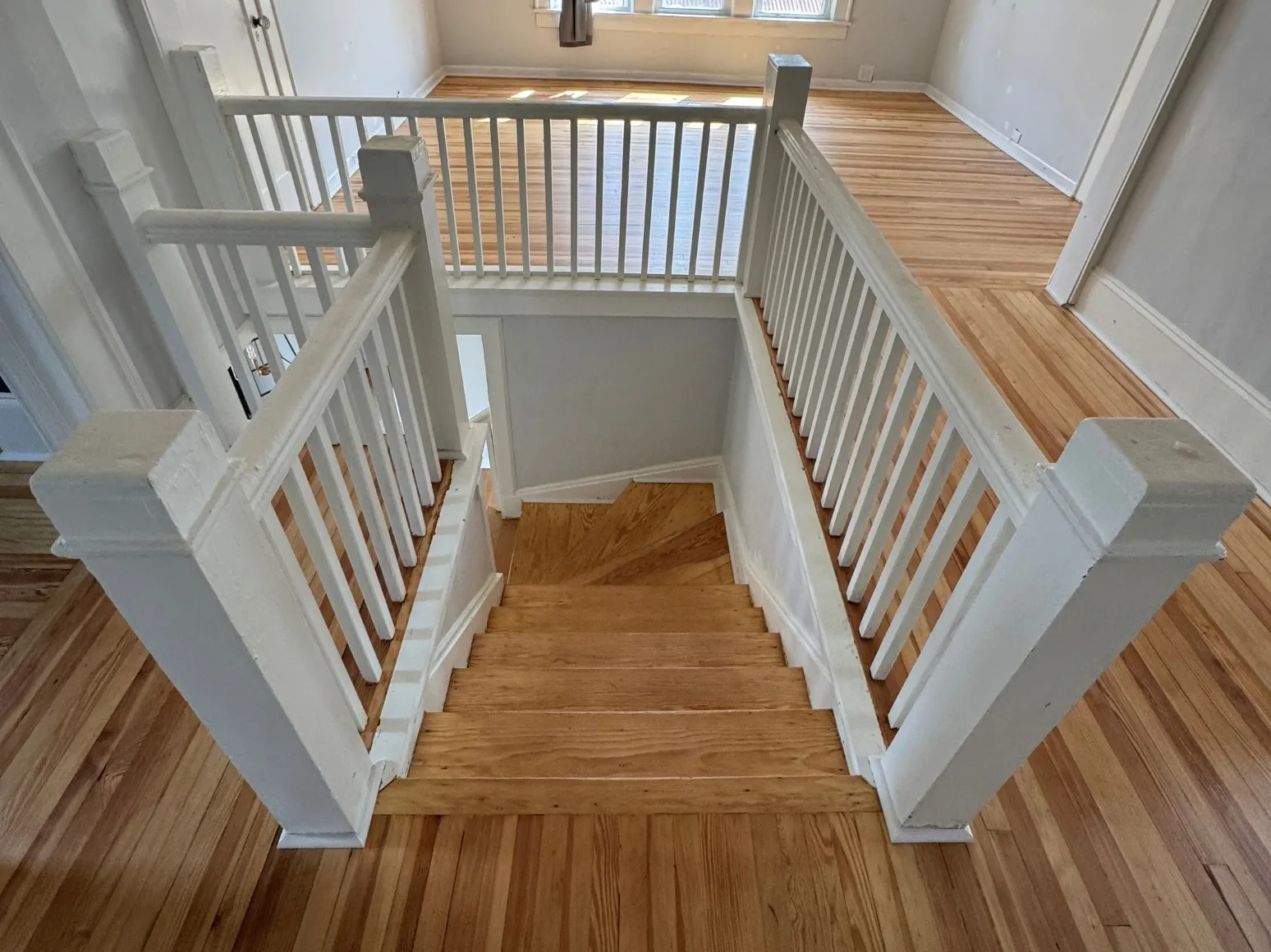 After staircase refinishing: Worn floor and stairs, sanded to bare oak