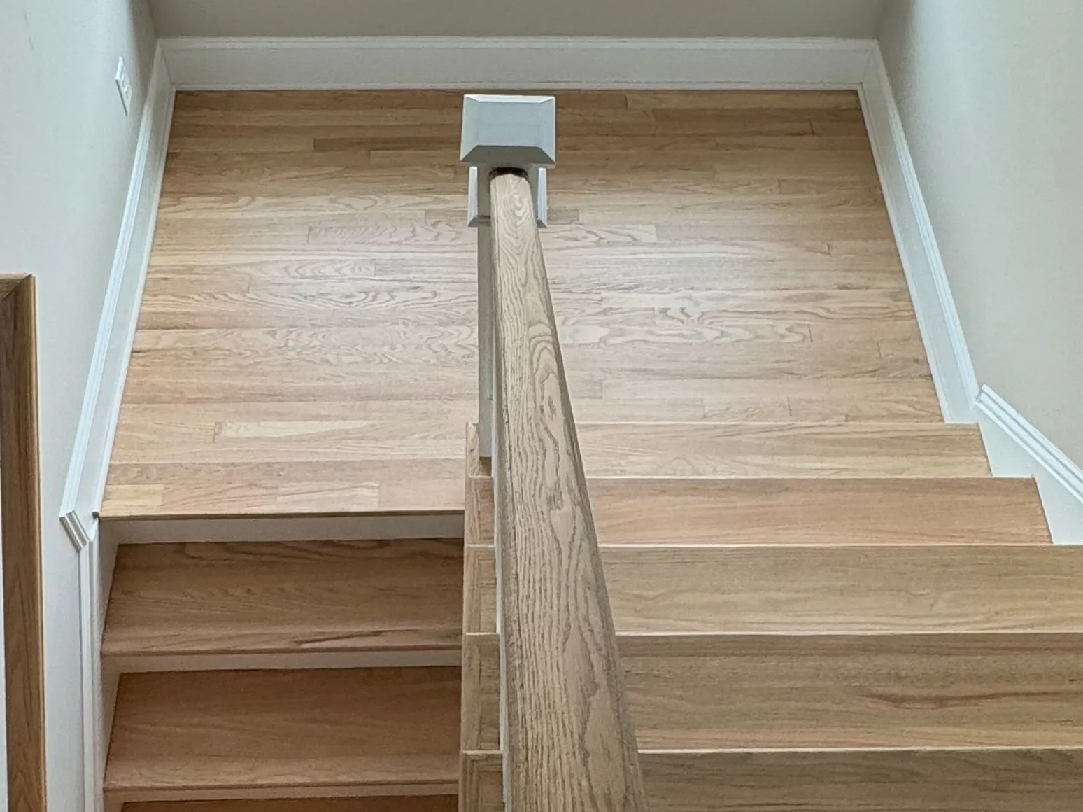 After staircase refinishing: Stair landing, dark brown to natural oak
