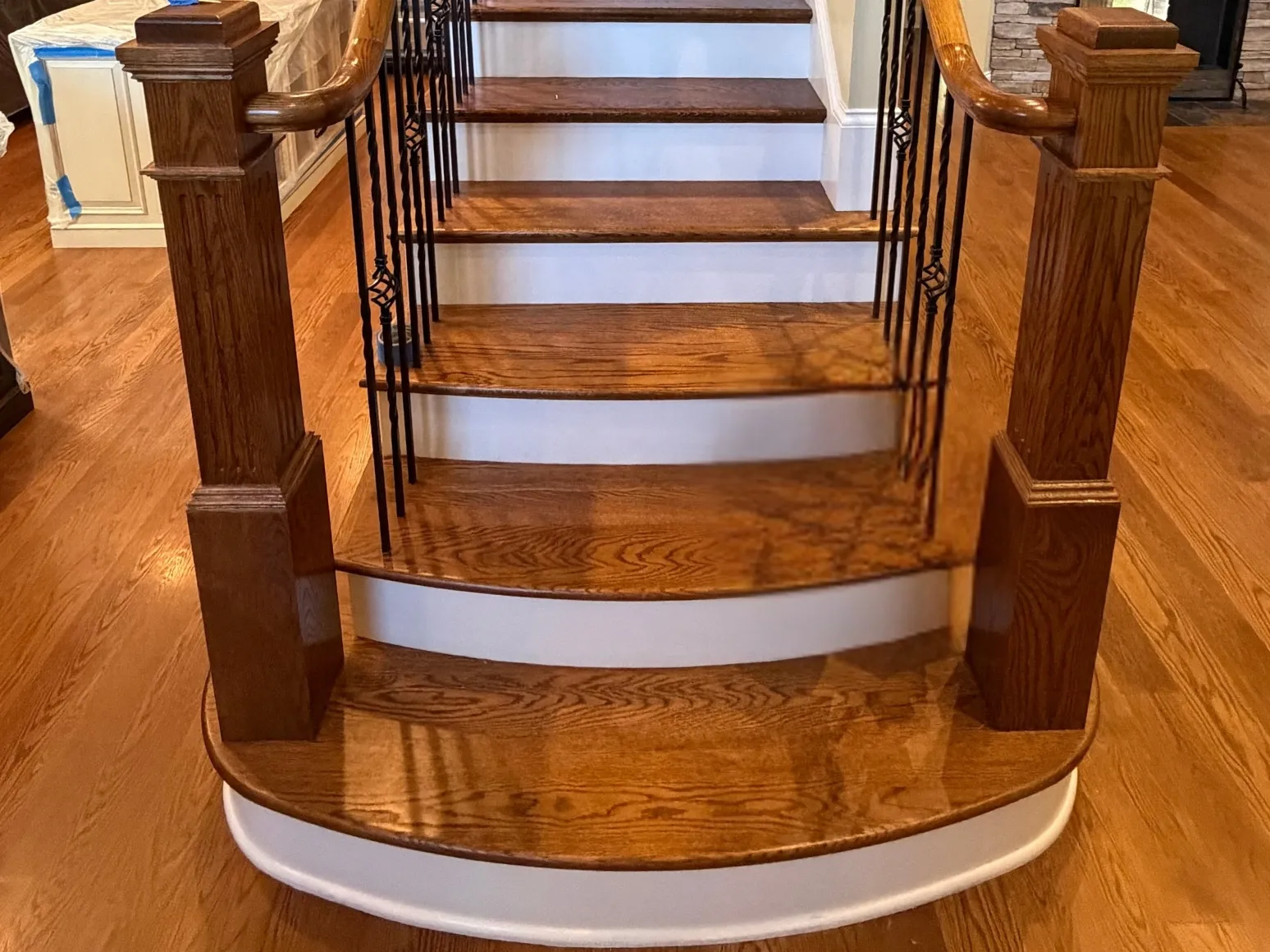 Before staircase refinishing: Curved entry stairs, dark stain to natural oak