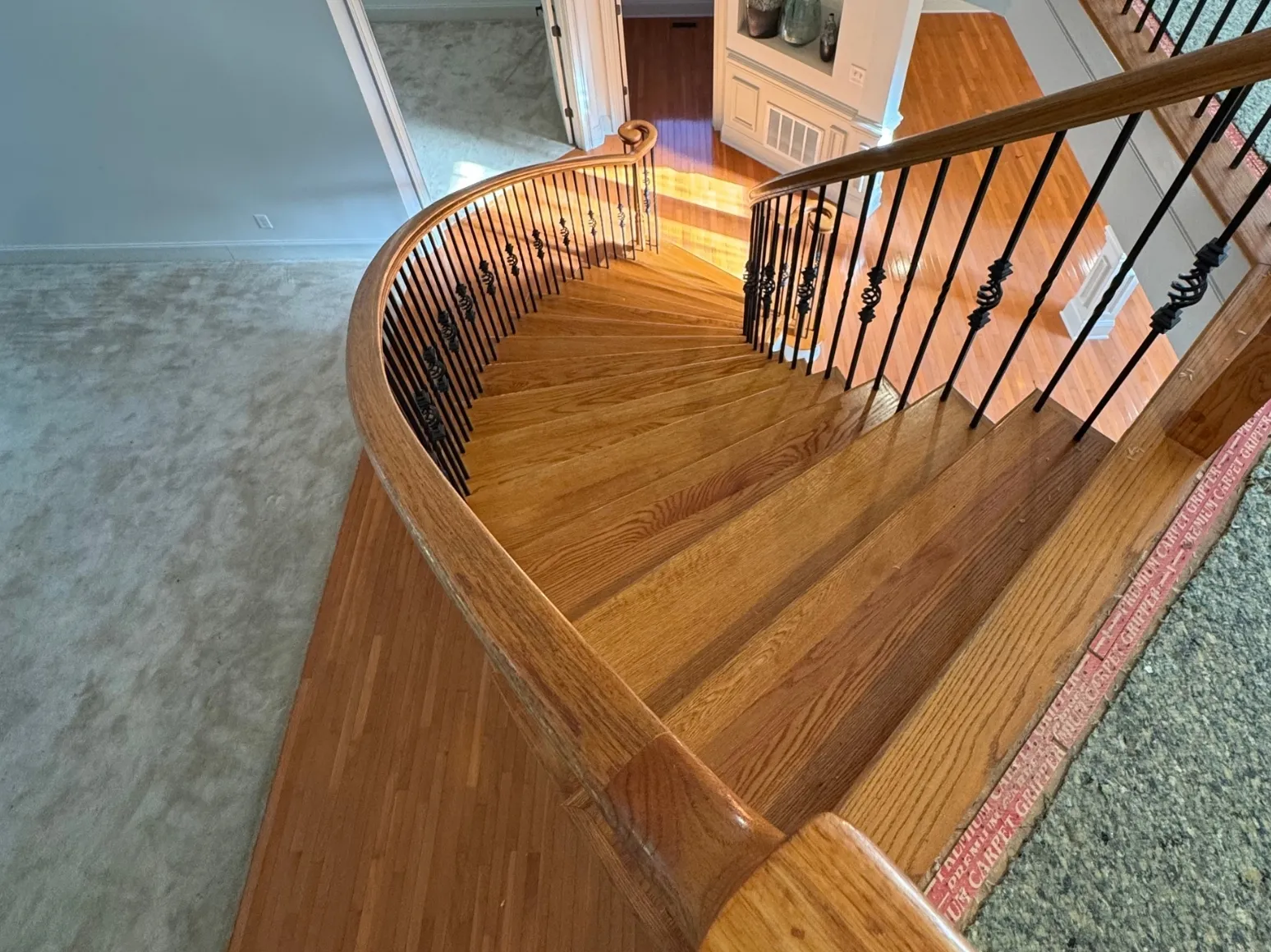 Before staircase refinishing: Curved staircase, orange oak to charcoal gray