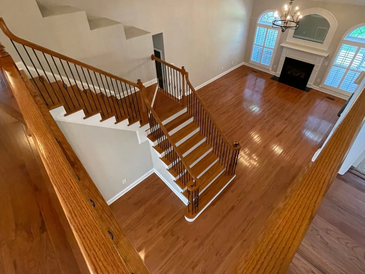 Before staircase refinishing: Open staircase and floor, glossy orange to natural