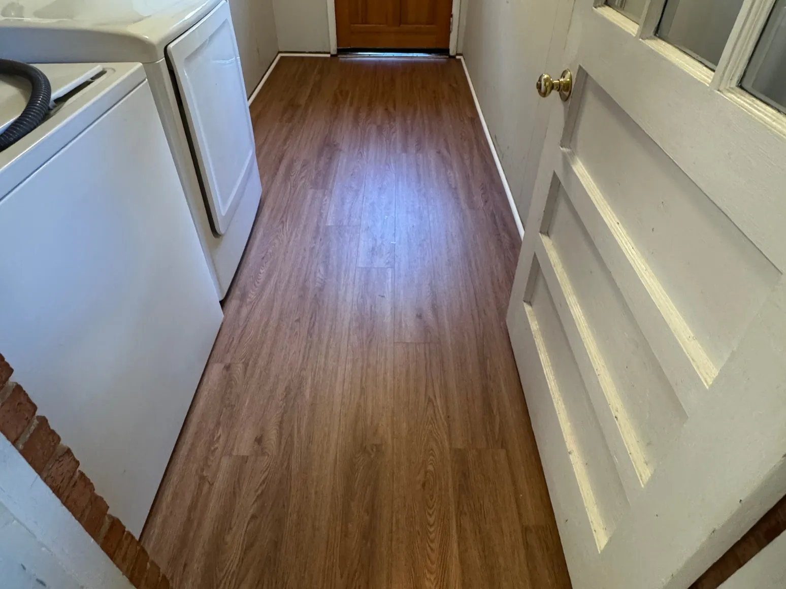 After luxury vinyl plank installation: Laundry hallway, checkerboard vinyl to wood-look LVP