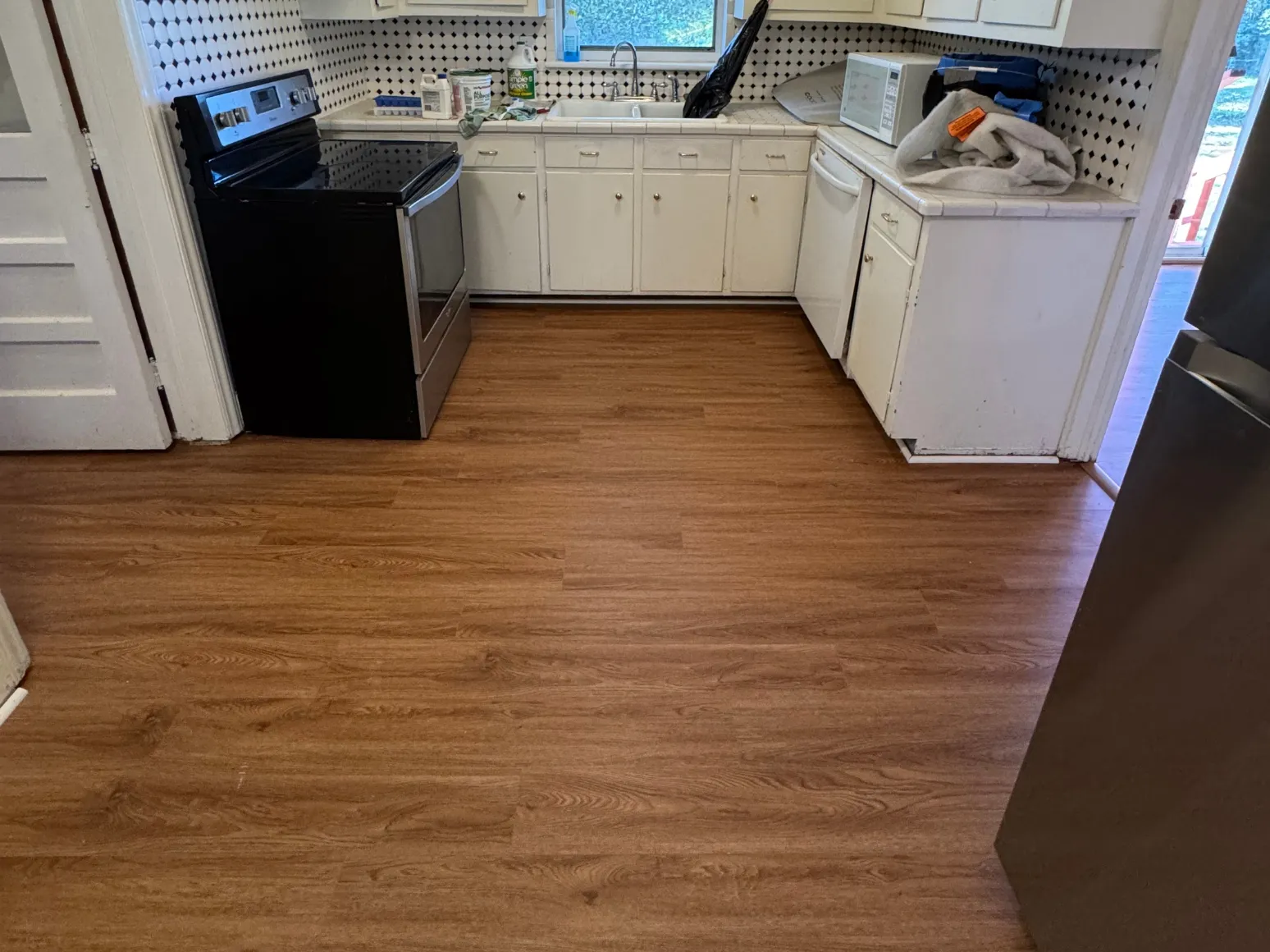 After luxury vinyl plank installation: Kitchen, black-and-white checkerboard to warm LVP