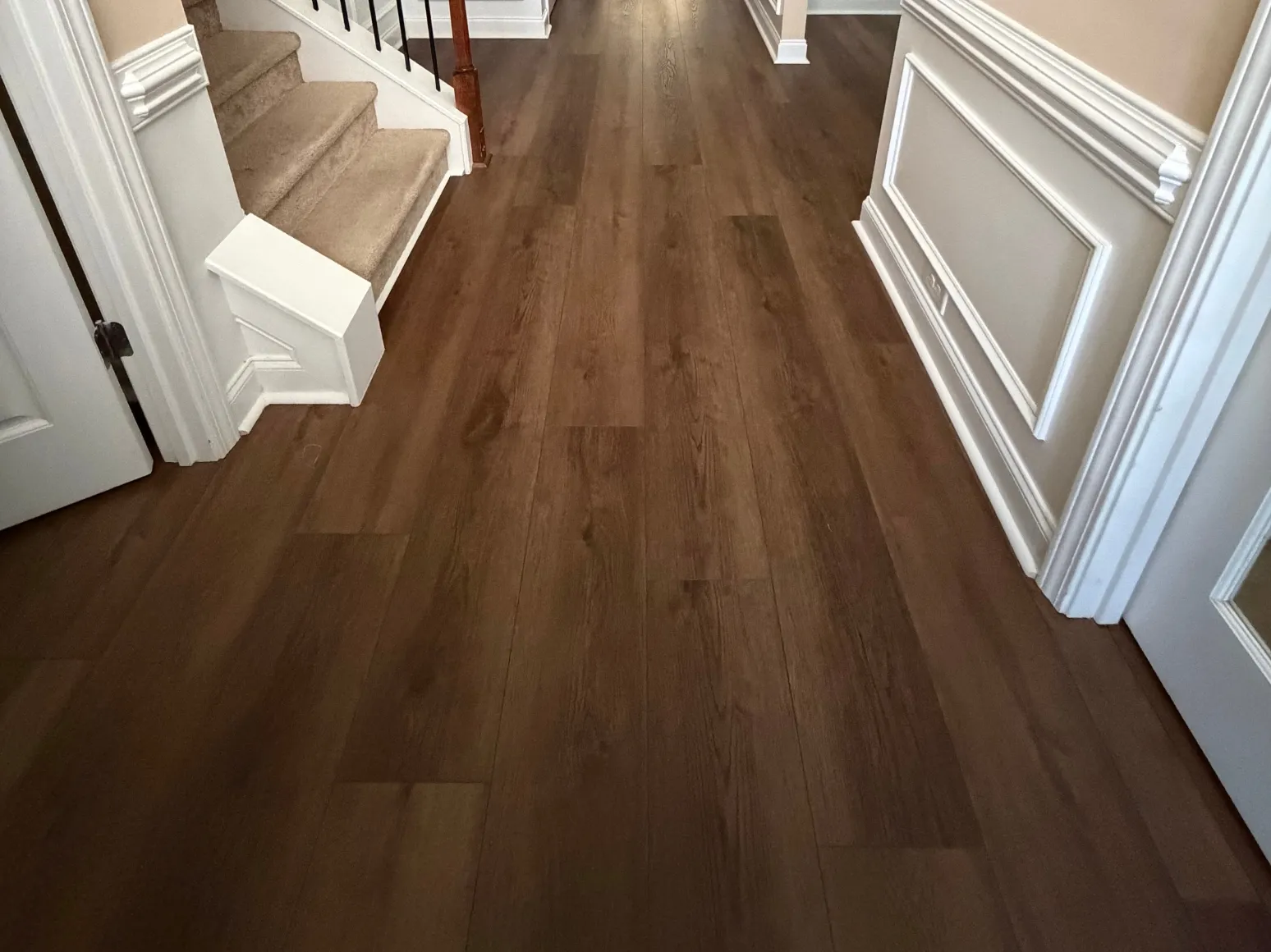 After luxury vinyl plank installation: Entry hall, red-brown planks to dark LVP