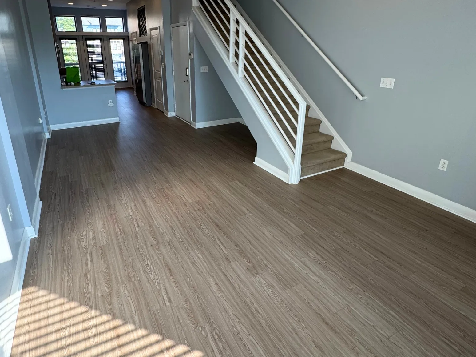 After luxury vinyl plank installation: Living room, carpet to gray-brown LVP