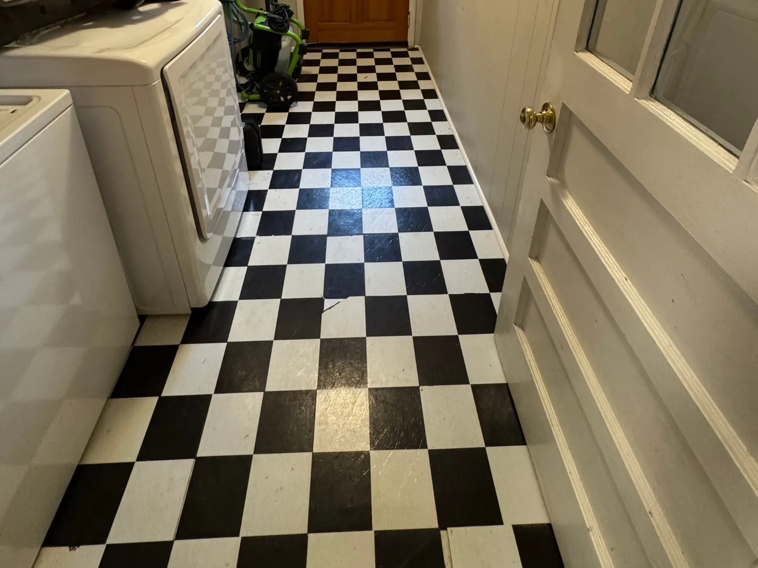 Before luxury vinyl plank installation: Laundry hallway, checkerboard vinyl to wood-look LVP