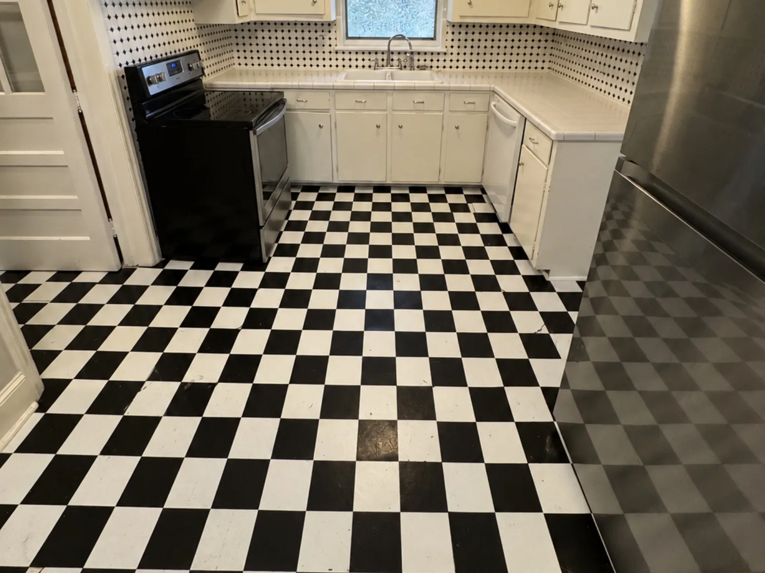 Before luxury vinyl plank installation: Kitchen, black-and-white checkerboard to warm LVP