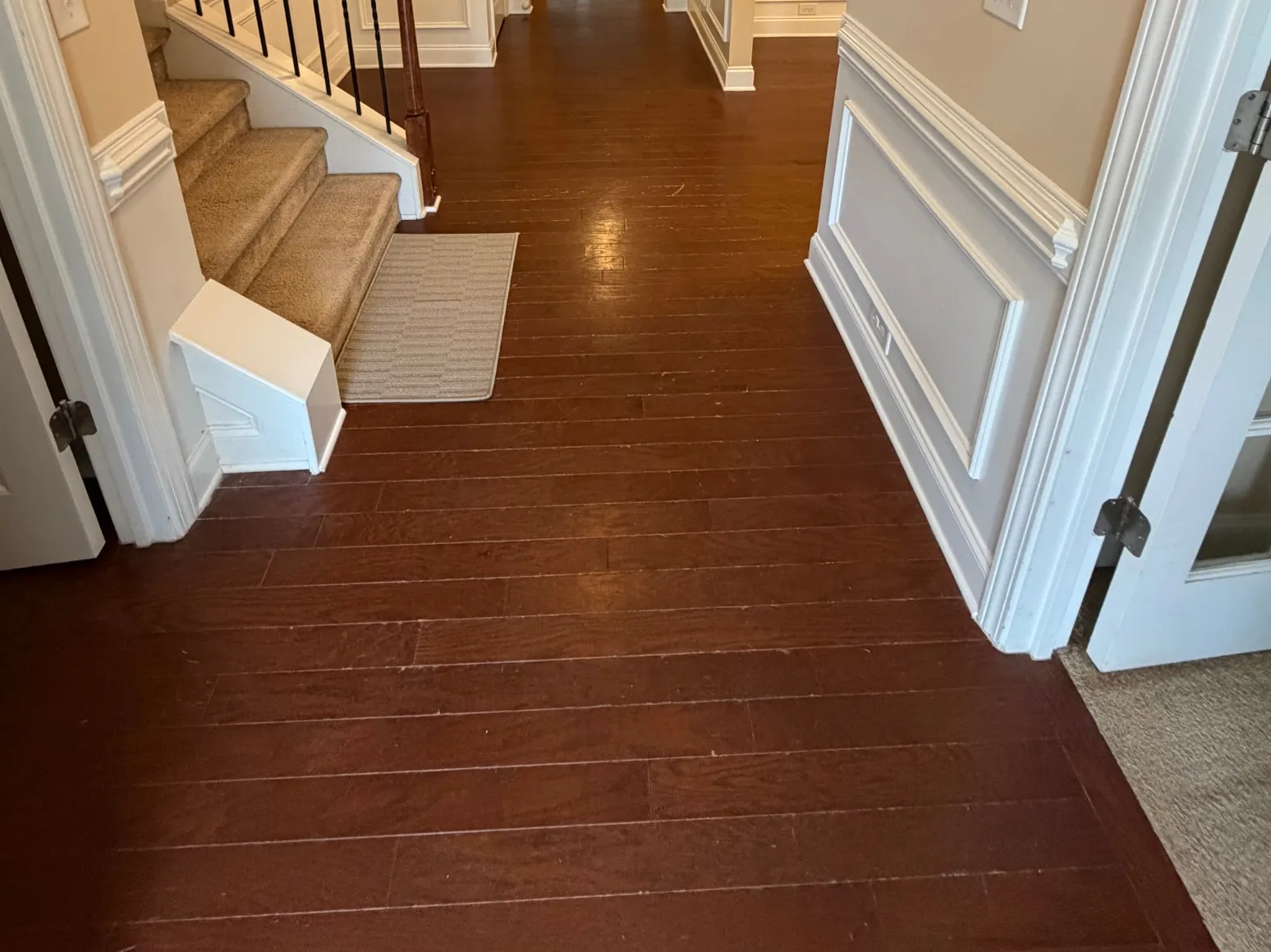 Before luxury vinyl plank installation: Entry hall, red-brown planks to dark LVP